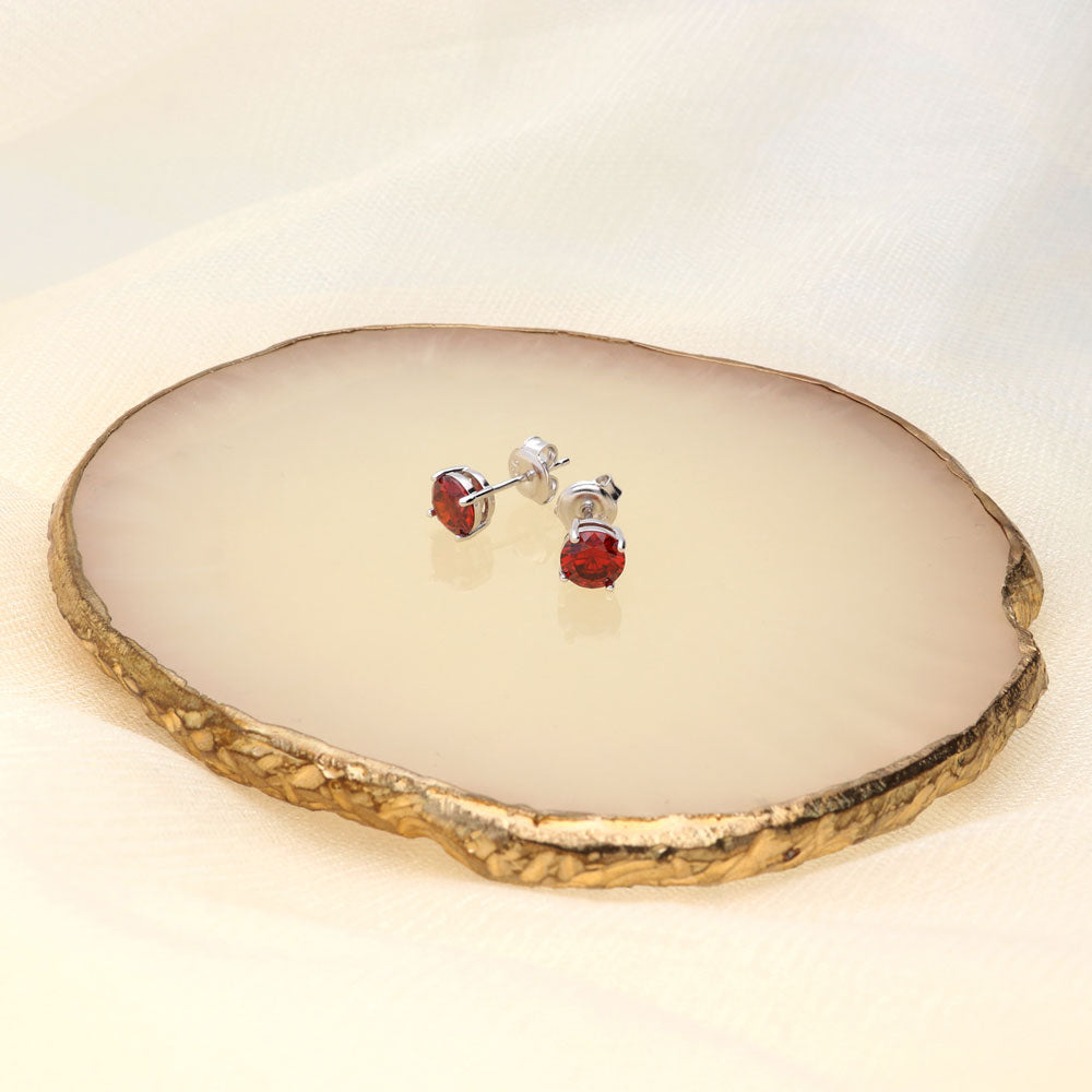 Flatlay view of Solitaire 1.6ct CZ Cartilage Stud Earrings in Sterling Silver, Garnet Color