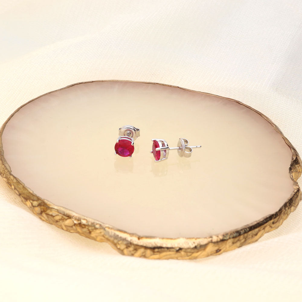 Flatlay view of Solitaire 1.6ct CZ Cartilage Stud Earrings in Sterling Silver, Ruby Color