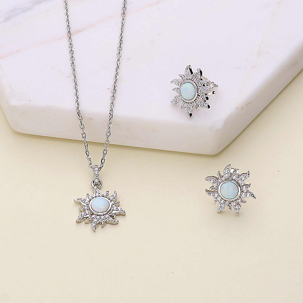 Flatlay view of Sun Sunburst Halo Opal-White CZ Stud Earrings in Sterling Silver, Yellow Gold Flashed