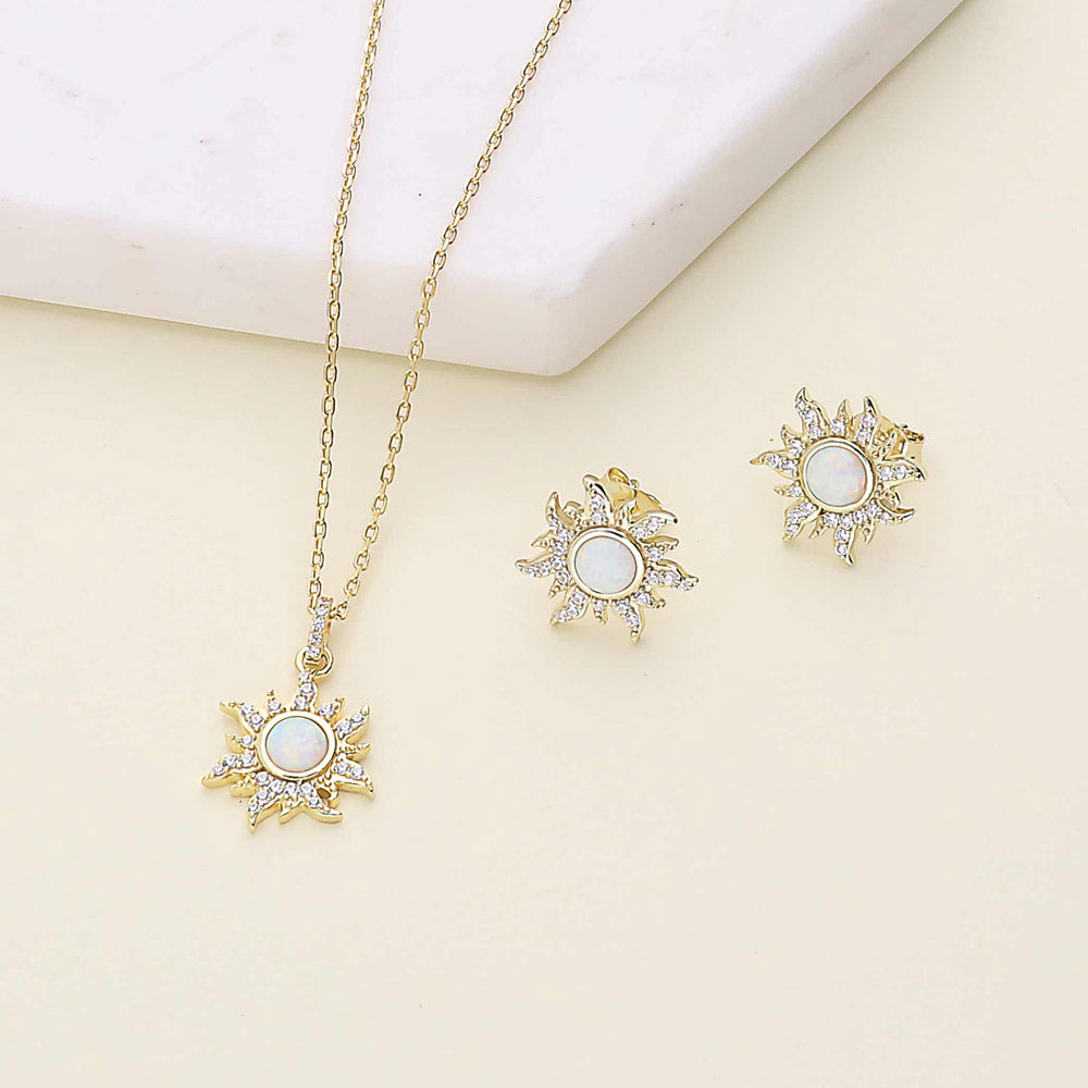 Flatlay view of Sun Sunburst Halo Opal-White CZ Stud Earrings in Sterling Silver, Yellow Gold Flashed