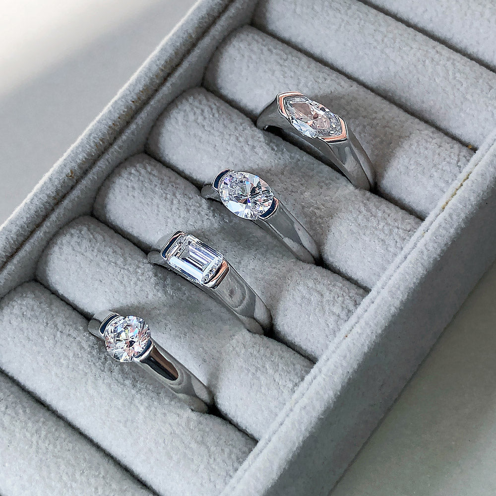 Flatlay view of East-West Solitaire Half Bezel Set CZ Ring in Sterling Silver