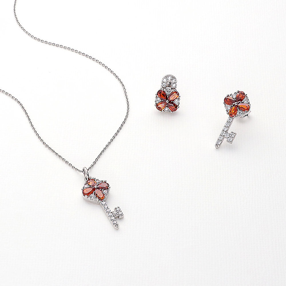 Flatlay view of Key and Lock CZ Stud Earrings in Sterling Silver, Red Color
