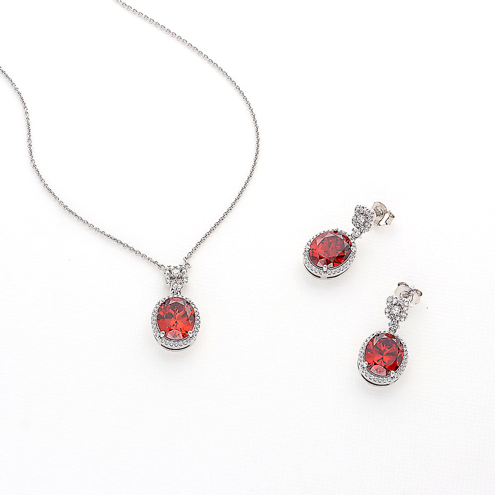 Flatlay view of Halo Clover Oval CZ Earrings in Sterling Silver, Red Color