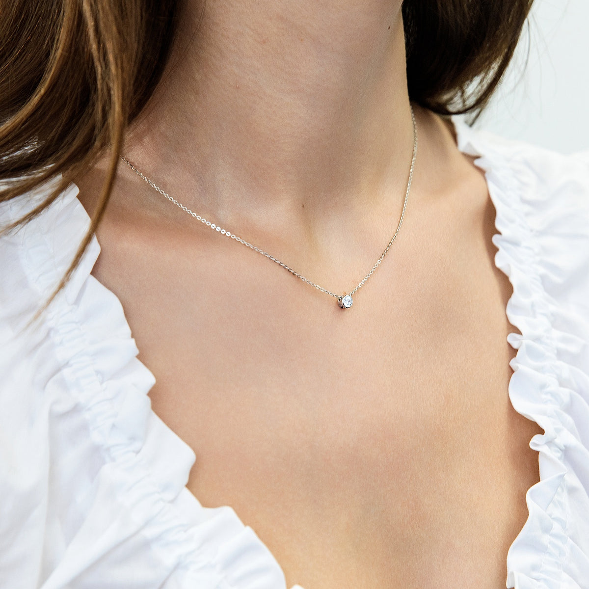 Model wearing Solitaire Bezel CZ Necklace in Sterling Silver, Rhodium Plated