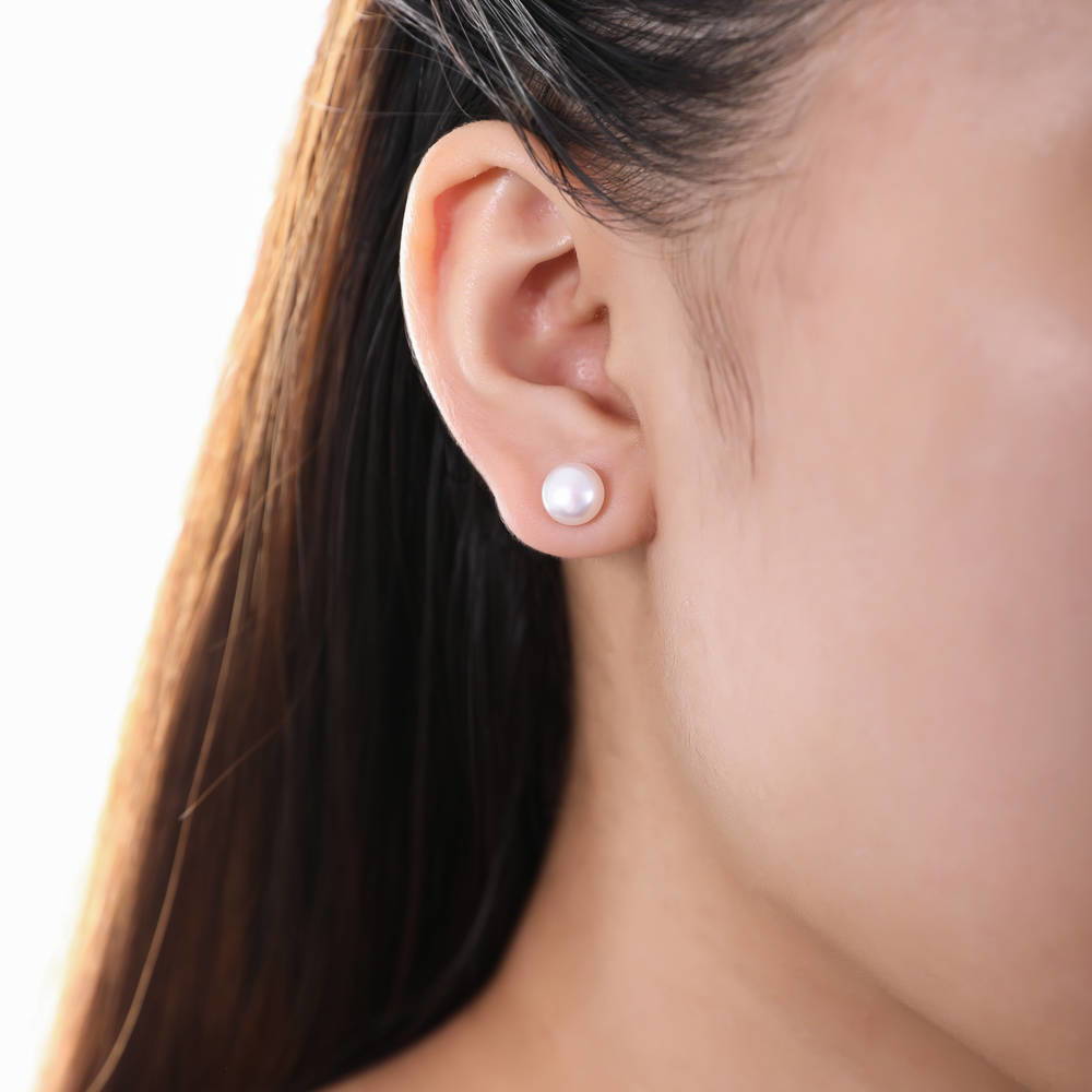 Model wearing Solitaire White Round Cultured Pearl Stud Earrings in Sterling Silver