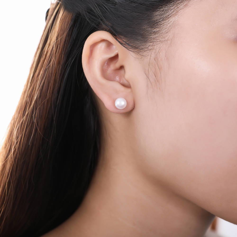 Model wearing Solitaire Cream Round Cultured Pearl Stud Earrings in Sterling Silver