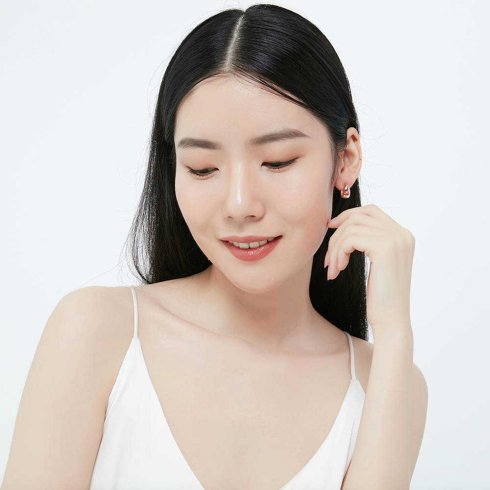 Model wearing Dome CZ Small Huggie Earrings in Sterling Silver 0.6 inch, Rose Gold Flashed