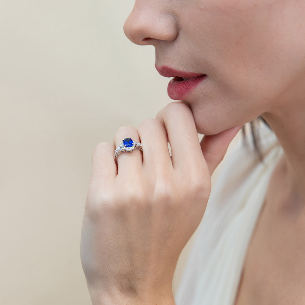 Model wearing Chevron Halo Simulated Blue Sapphire CZ Ring Set in Sterling Silver