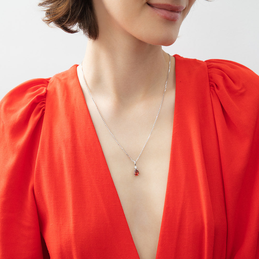 Model wearing Solitaire 1ct Pear CZ Necklace in Sterling Silver, Garnet Color