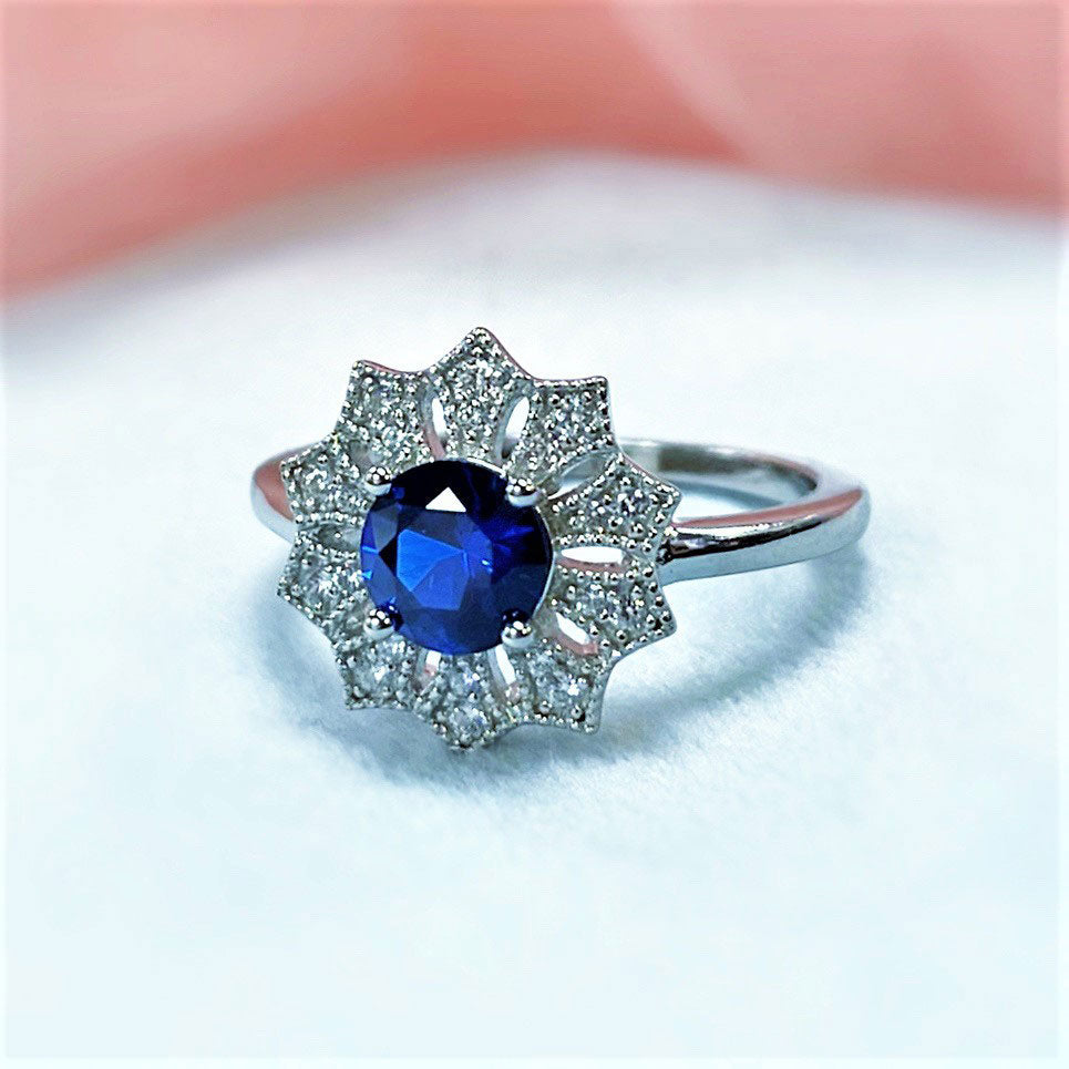 Flatlay view of Flower Halo Blue CZ Ring in Sterling Silver