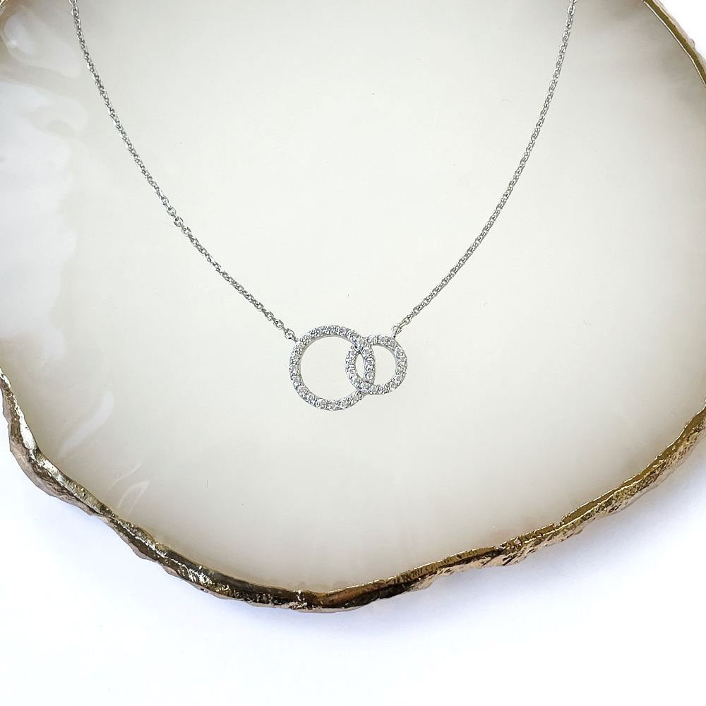 Flatlay view of Open Circle Interlocking CZ Pendant Necklace in Sterling Silver