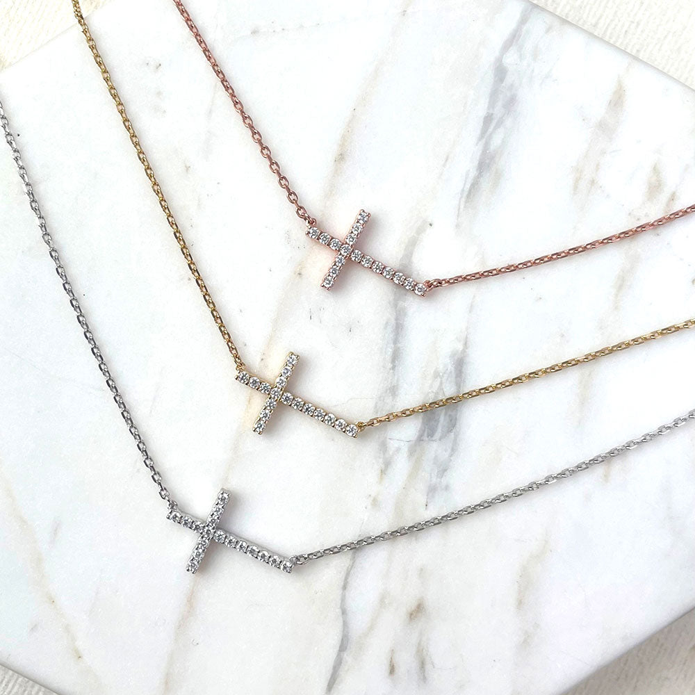 Flatlay view of Sideways Cross CZ Pendant Necklace in Rose Gold Flashed Sterling Silver