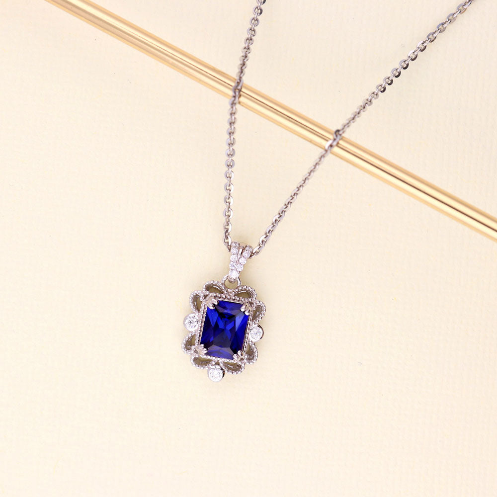 Flatlay view of Milgrain Simulated Blue Sapphire CZ Pendant Necklace in Sterling Silver