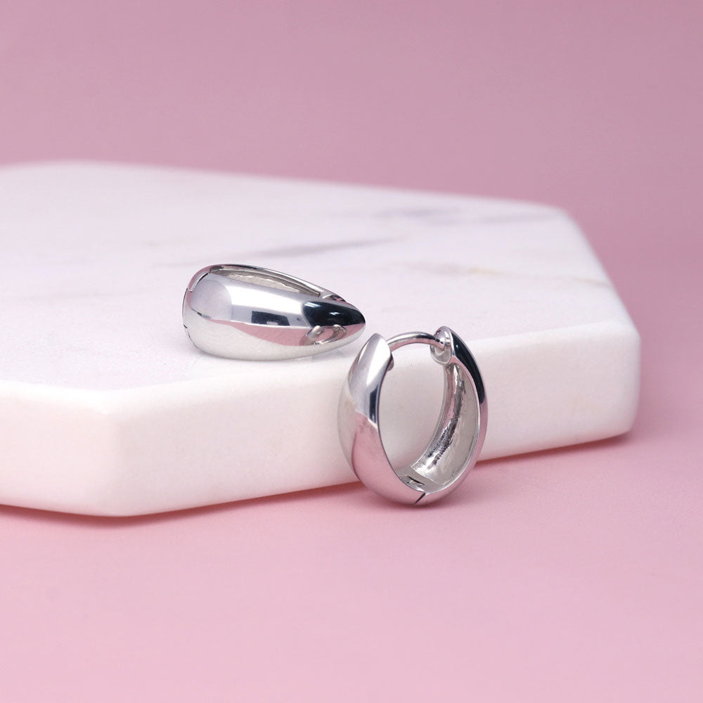 Flatlay view of Oval Dome Medium Huggie Earrings in Sterling Silver 0.63 inch