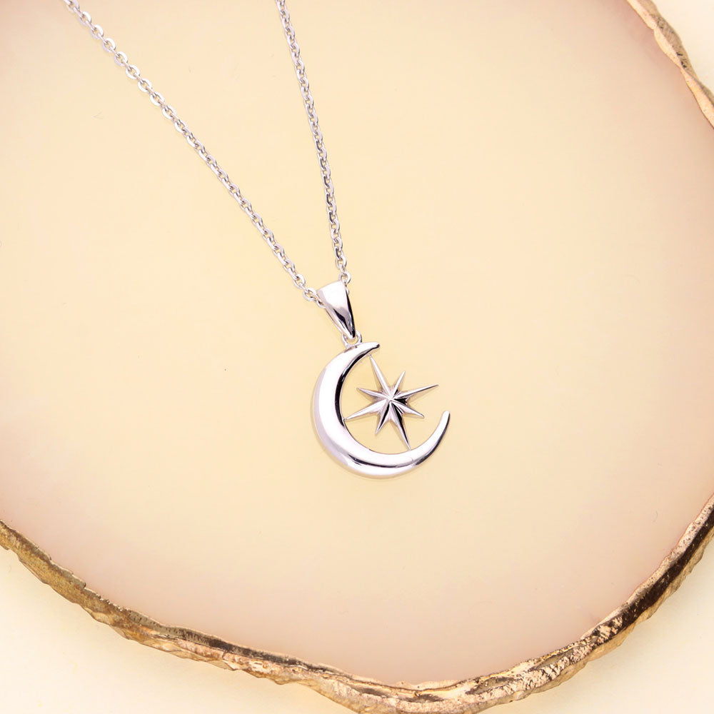 Flatlay view of Crescent Moon North Star Necklace and Earrings Set in Sterling Silver