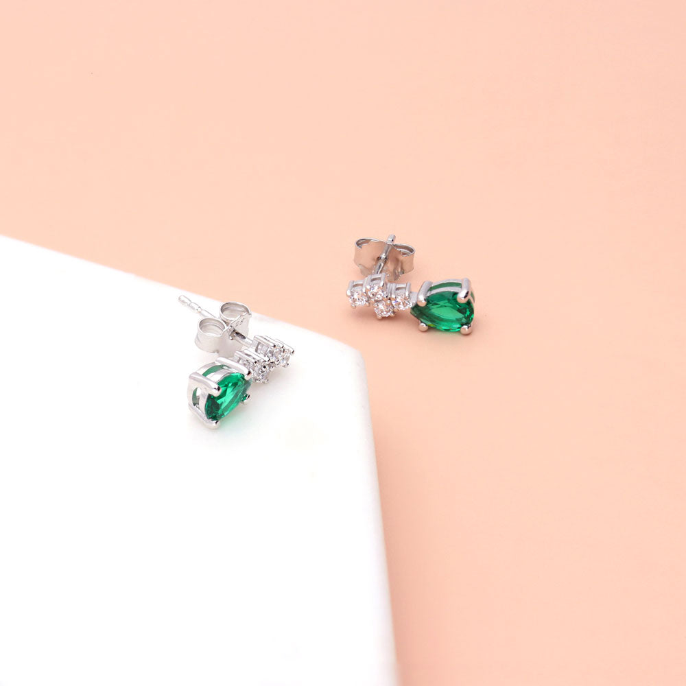 Flatlay view of Cluster Simulated Emerald CZ Stud Earrings in Sterling Silver