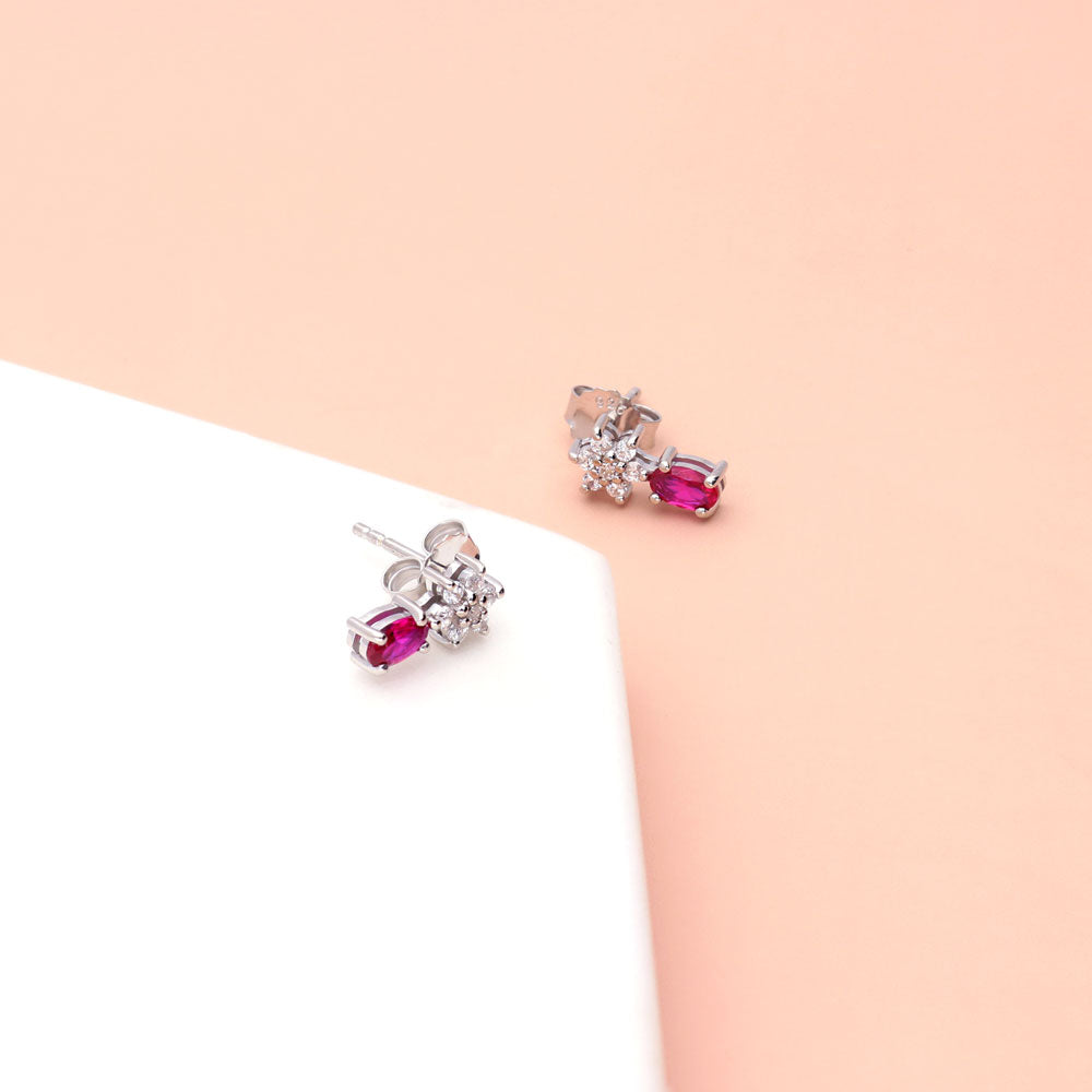Flatlay view of Flower Simulated Ruby CZ Stud Earrings in Sterling Silver