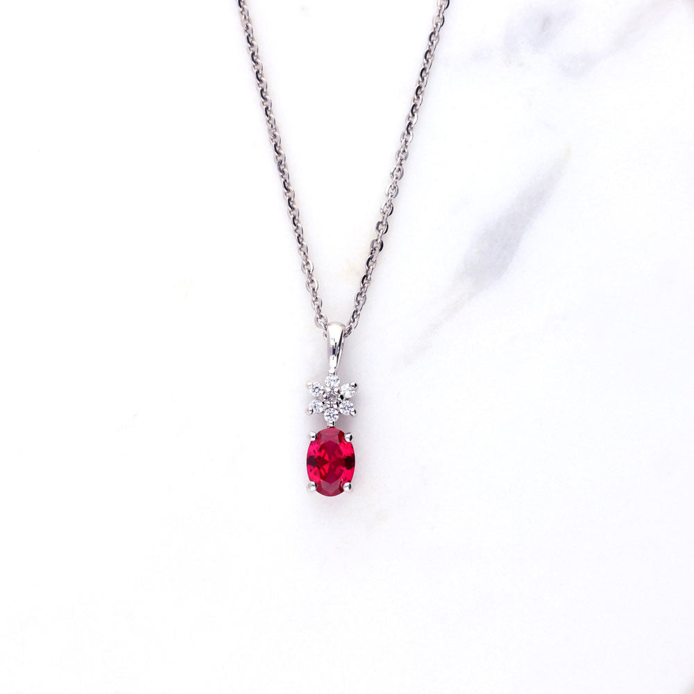 Flatlay view of Flower Simulated Ruby CZ Pendant Necklace in Sterling Silver