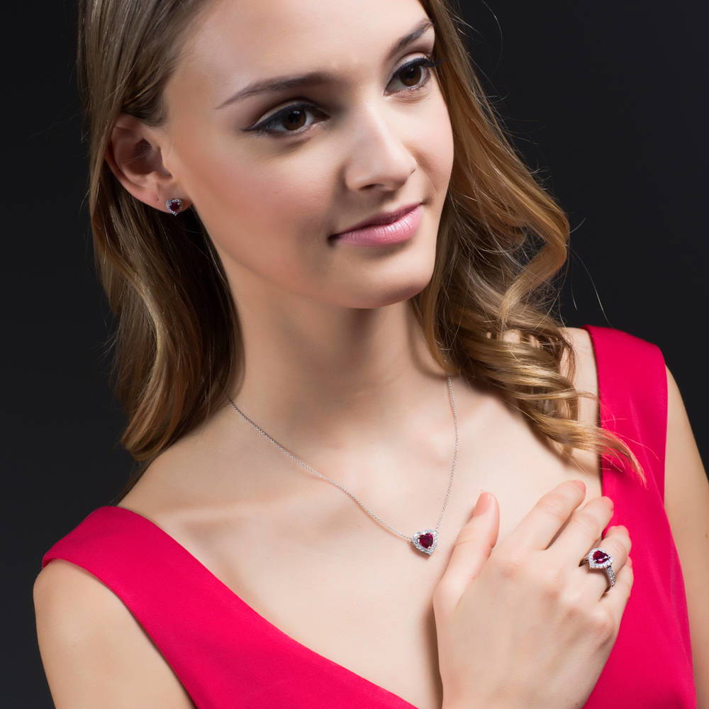 Model wearing Halo Heart Simulated Ruby CZ Stud Earrings in Sterling Silver