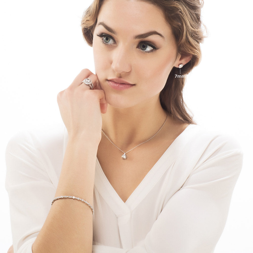 Model wearing Solitaire Bezel Set Round CZ Stud Earrings in Sterling Silver