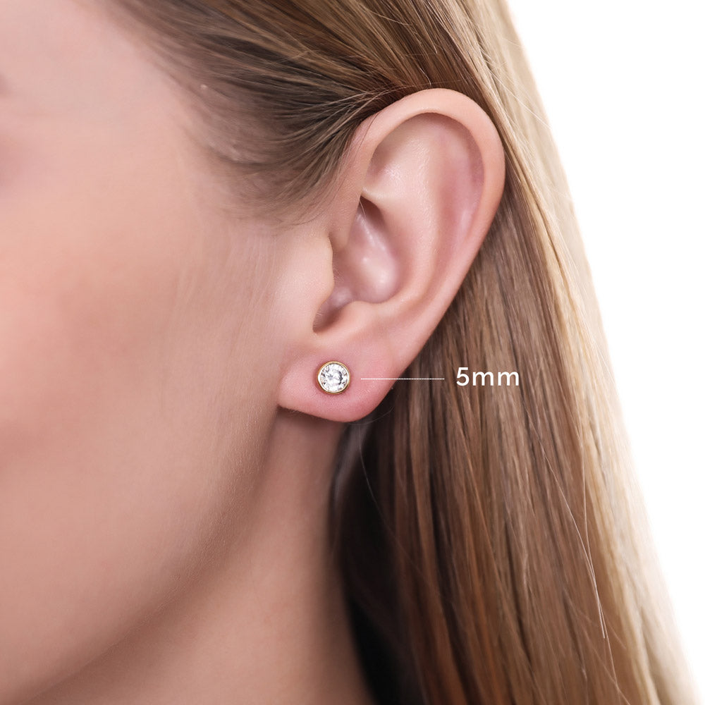 Model wearing Solitaire Bezel Set Round CZ Stud Earrings in Sterling Silver