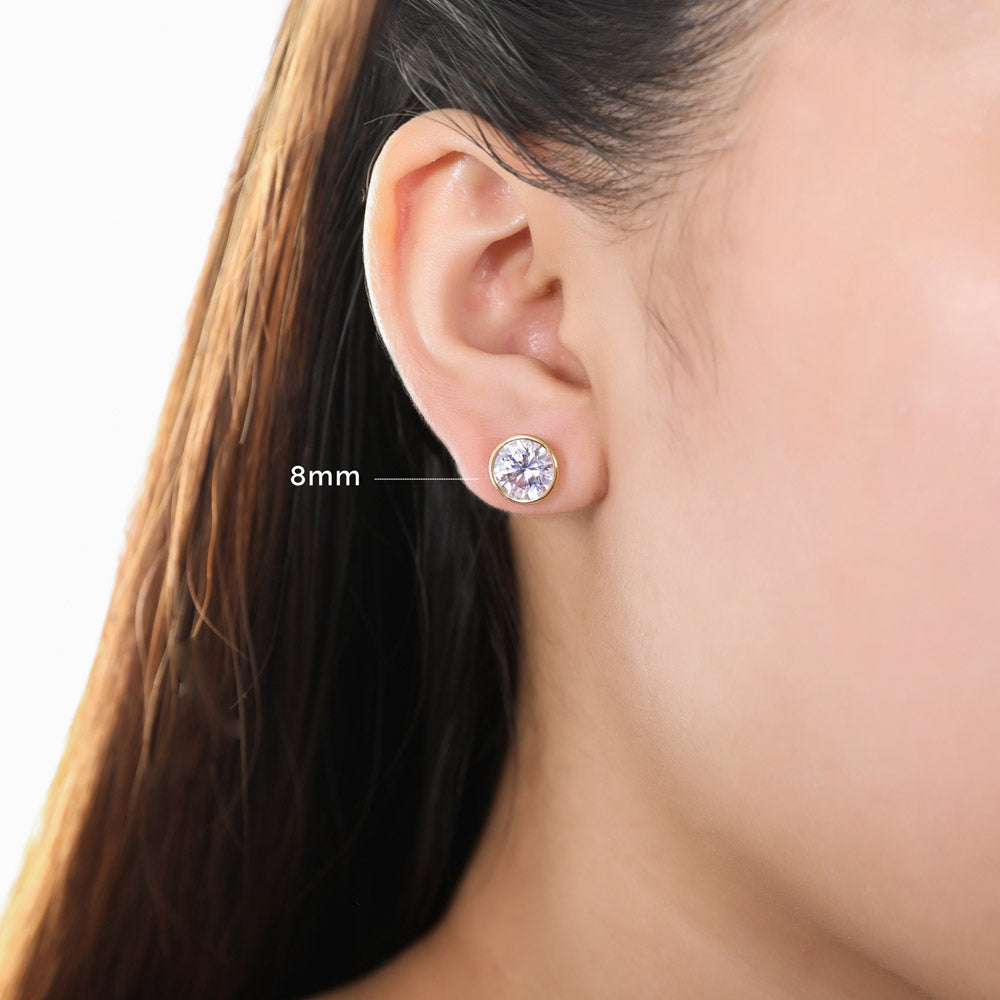 Model wearing Solitaire Bezel Set Round CZ Stud Earrings in Sterling Silver