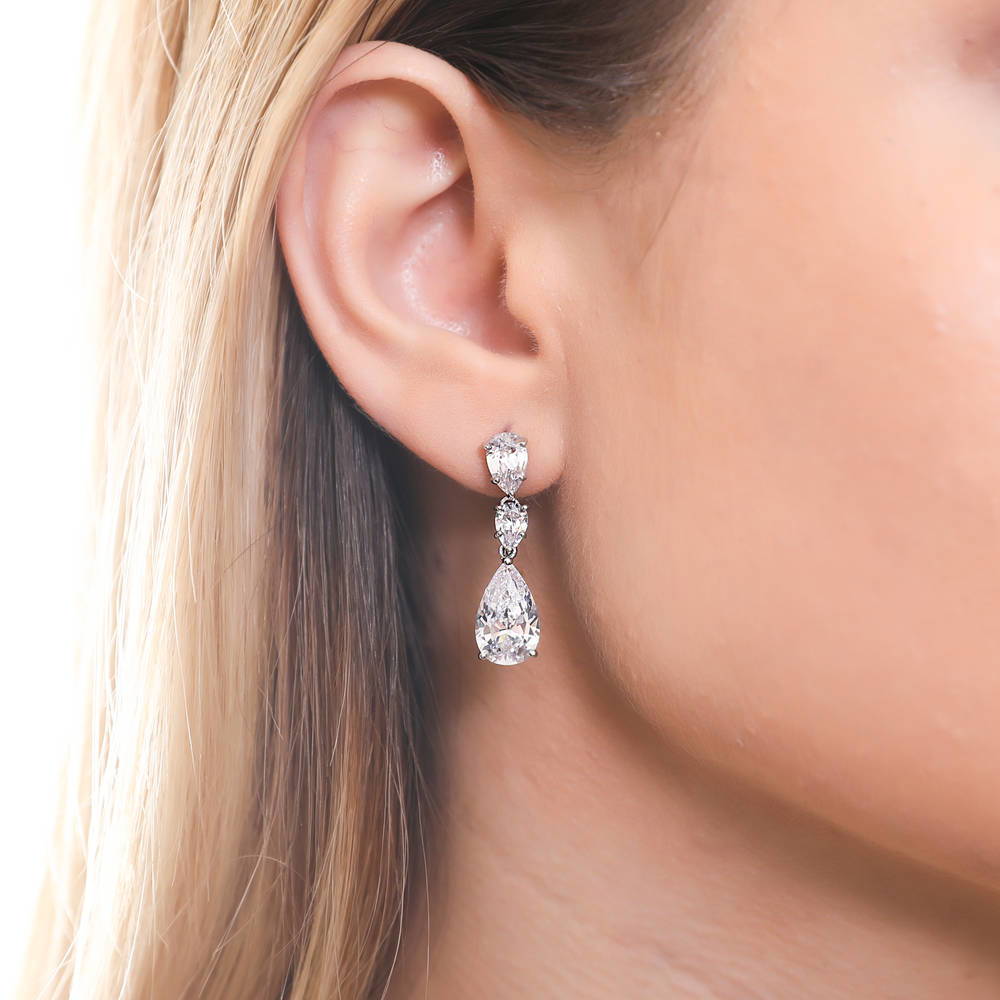 Model wearing 3-Stone Graduated Pear CZ Dangle Earrings in Sterling Silver