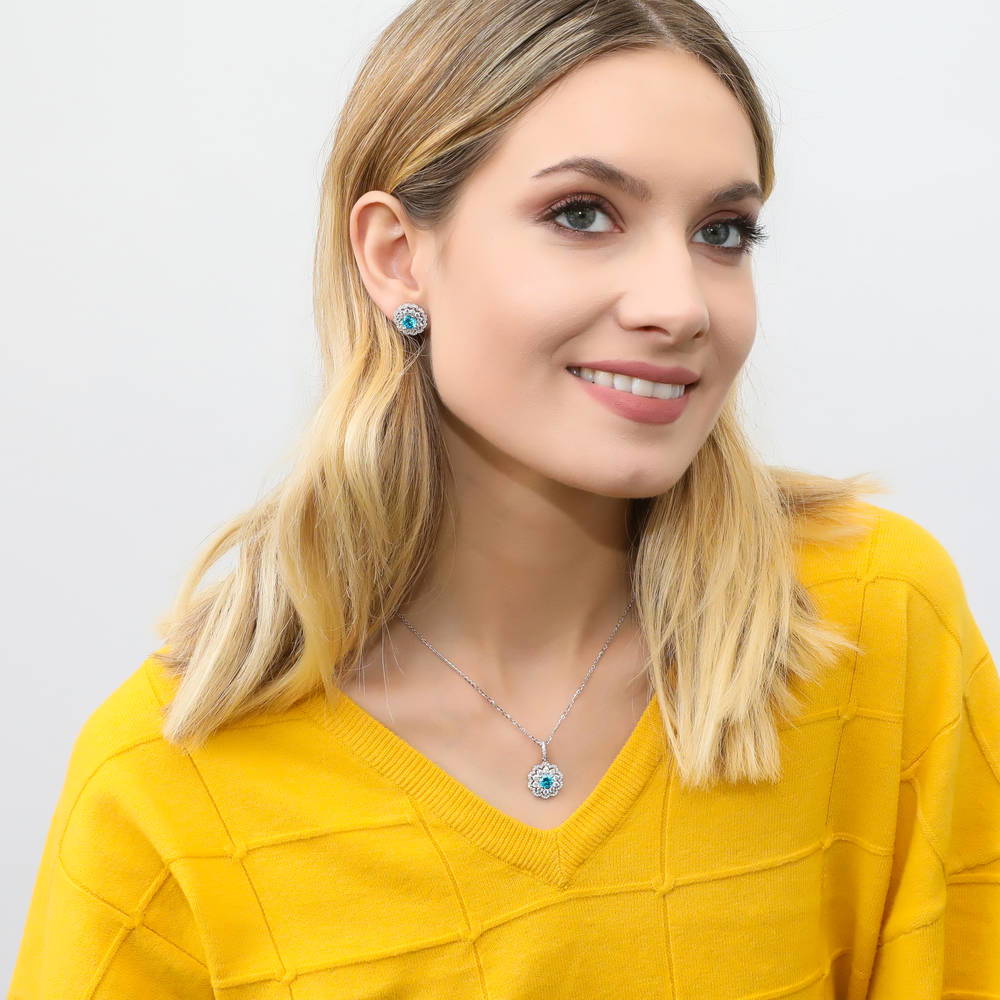 Model wearing Flower Halo Blue CZ Stud Earrings in Sterling Silver