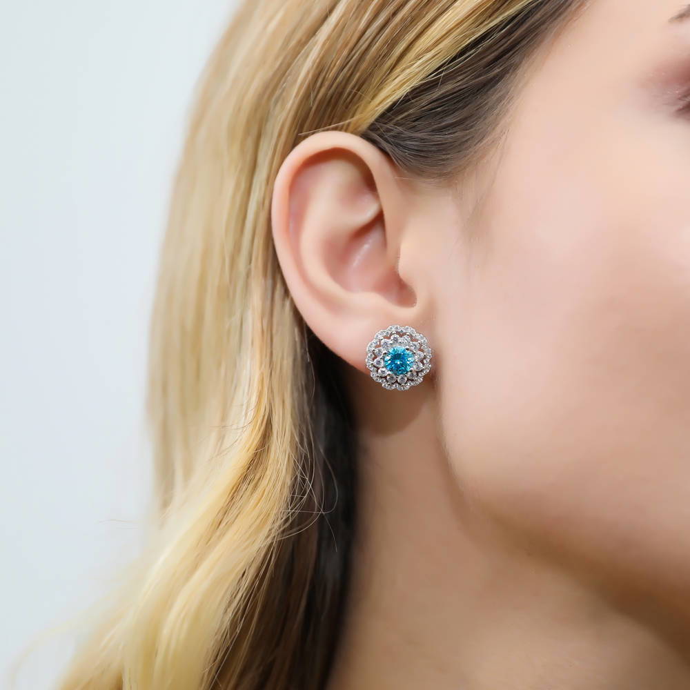 Model wearing Flower Halo Blue CZ Stud Earrings in Sterling Silver