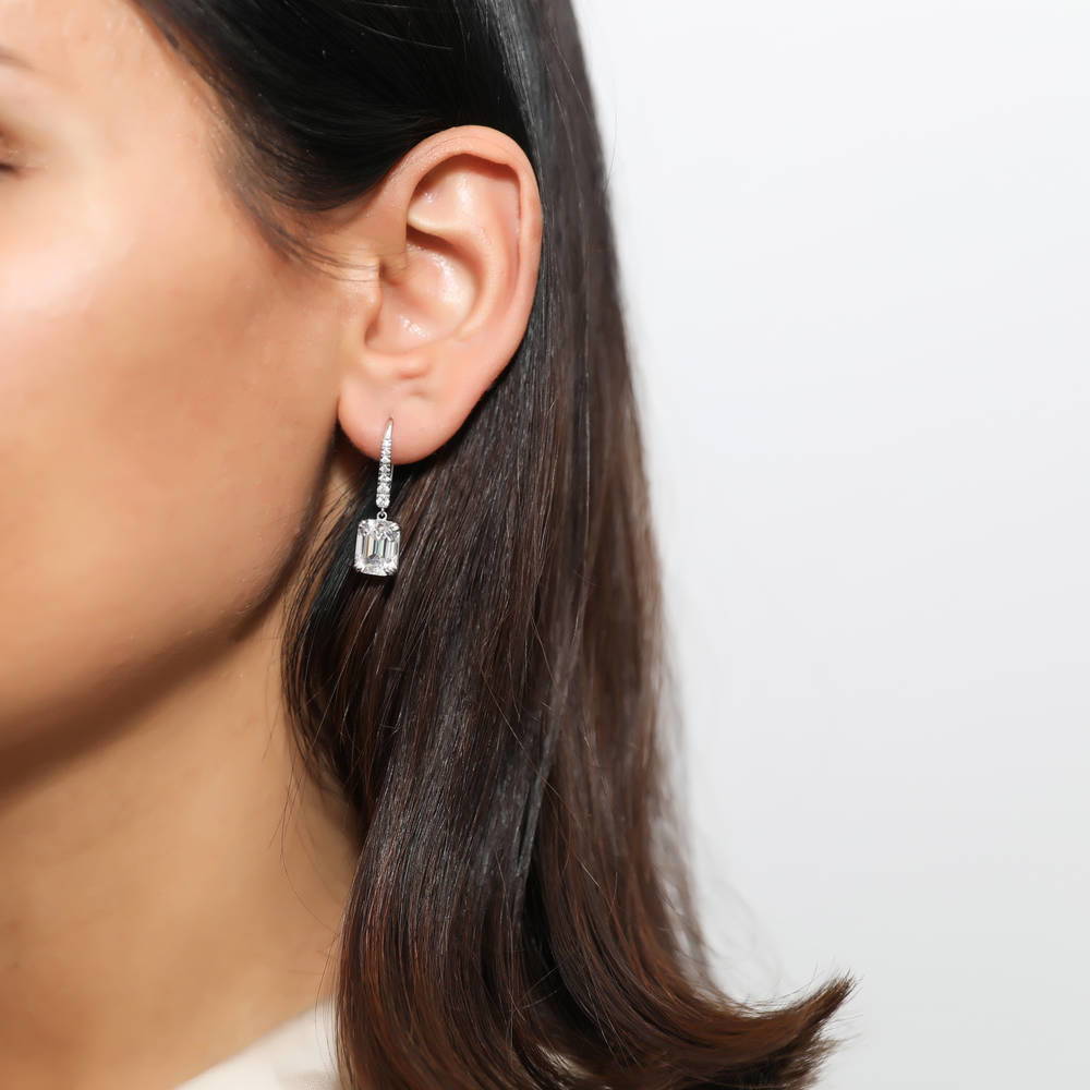 Model wearing Solitaire 7.6ct Emerald Cut CZ Leverback Earrings in Sterling Silver