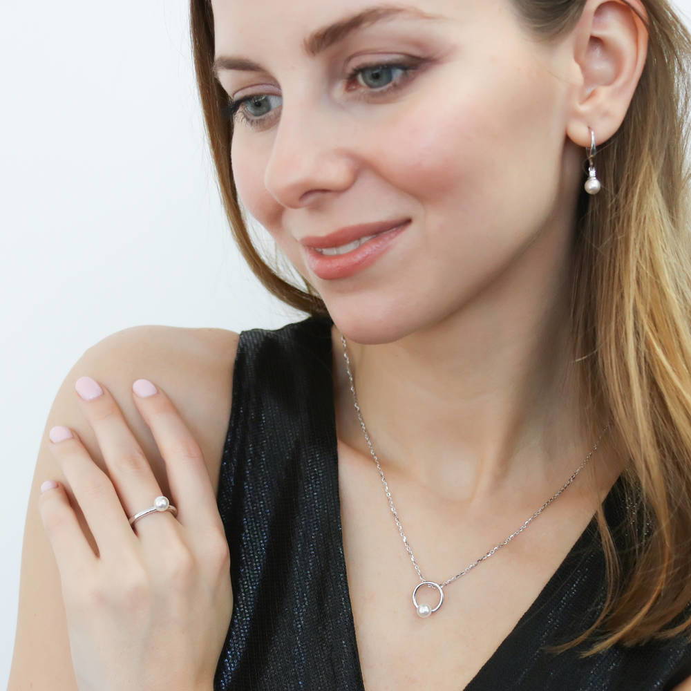 Model wearing Solitaire White Round Imitation Pearl Earrings in Sterling Silver