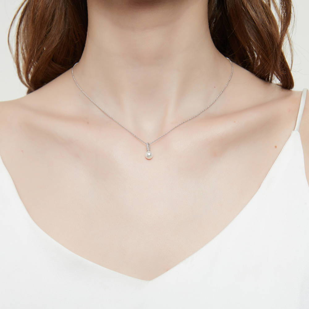 Model wearing Solitaire White Round Imitation Pearl Necklace in Sterling Silver