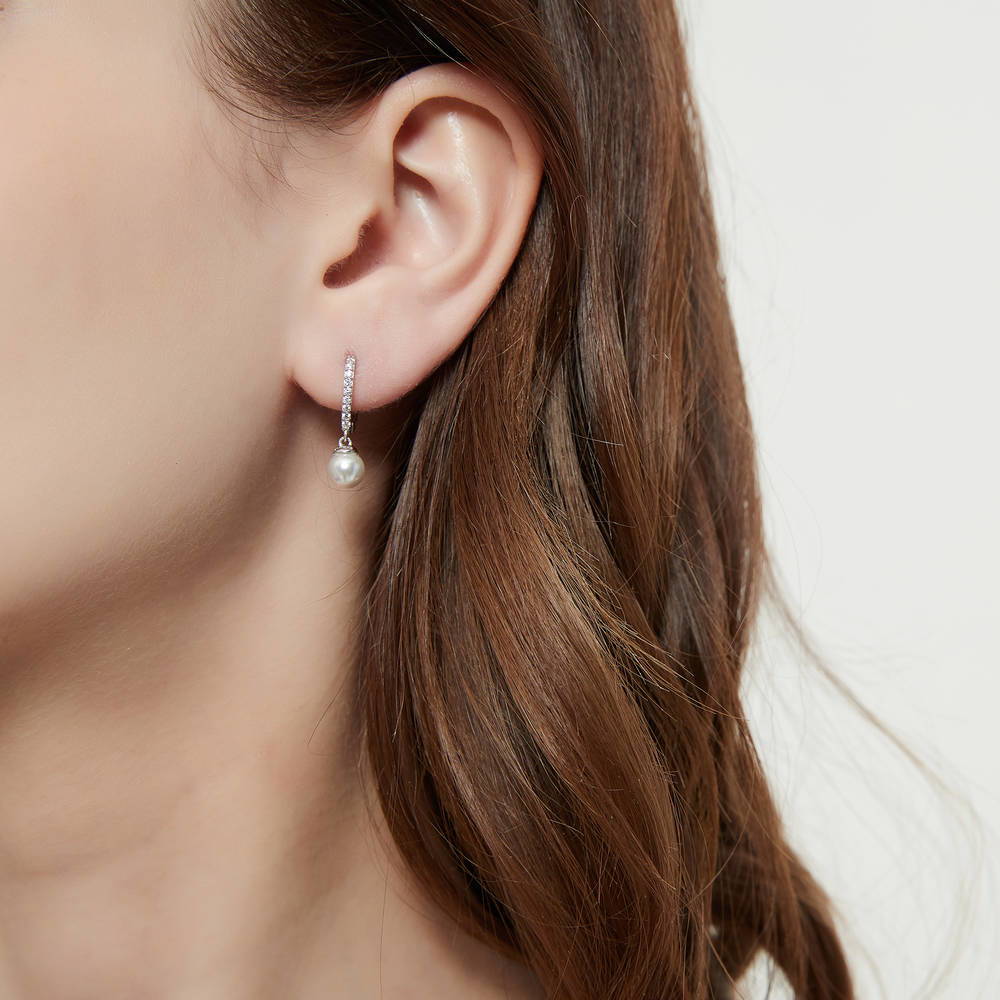 Model wearing Solitaire White Round Imitation Pearl Earrings in Sterling Silver