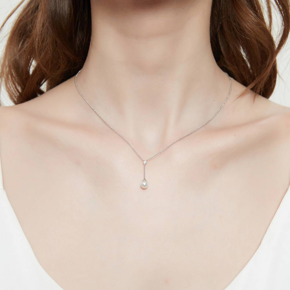 Model wearing Solitaire White Round Imitation Pearl Necklace in Sterling Silver