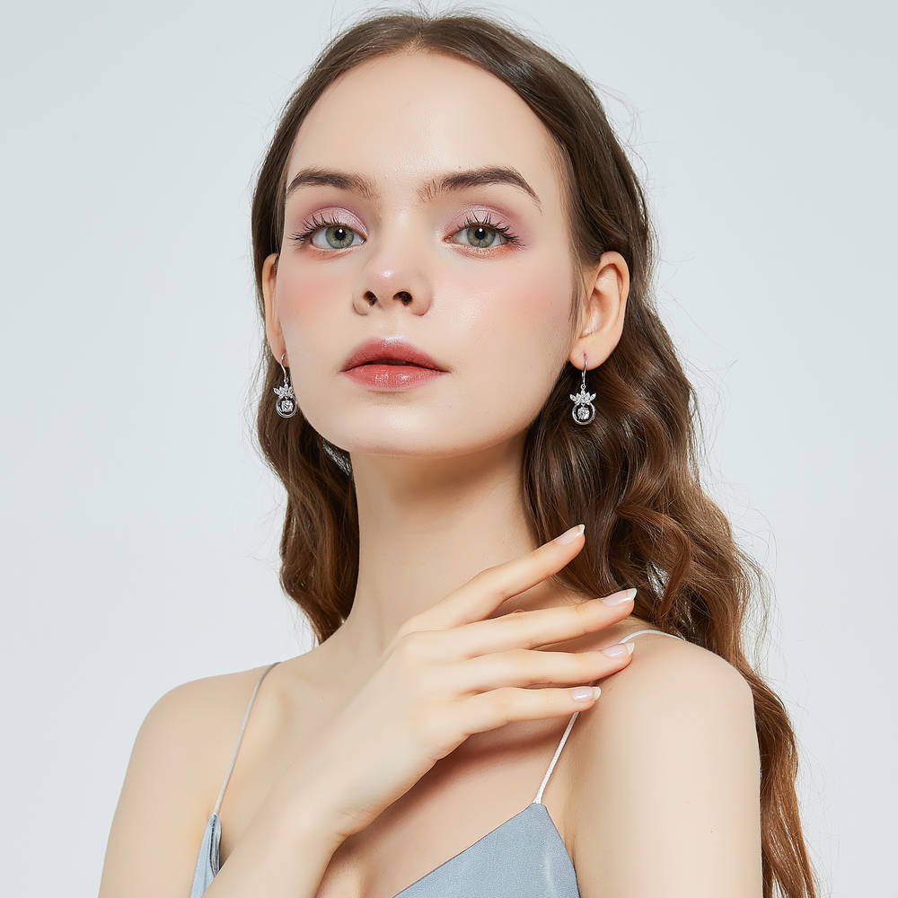 Model wearing Crown Solitaire CZ Fish Hook Dangle Earrings in Sterling Silver