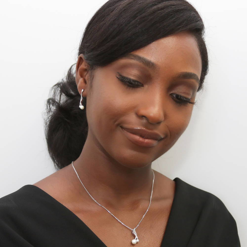 Model wearing Infinity White Round Cultured Pearl Earrings in Sterling Silver