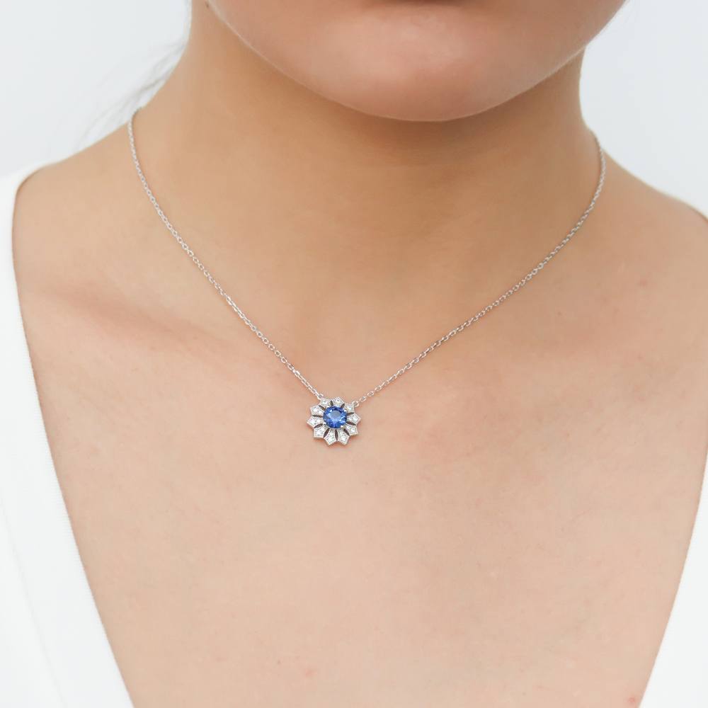 Model wearing Halo Flower Blue Round CZ Pendant Necklace in Sterling Silver
