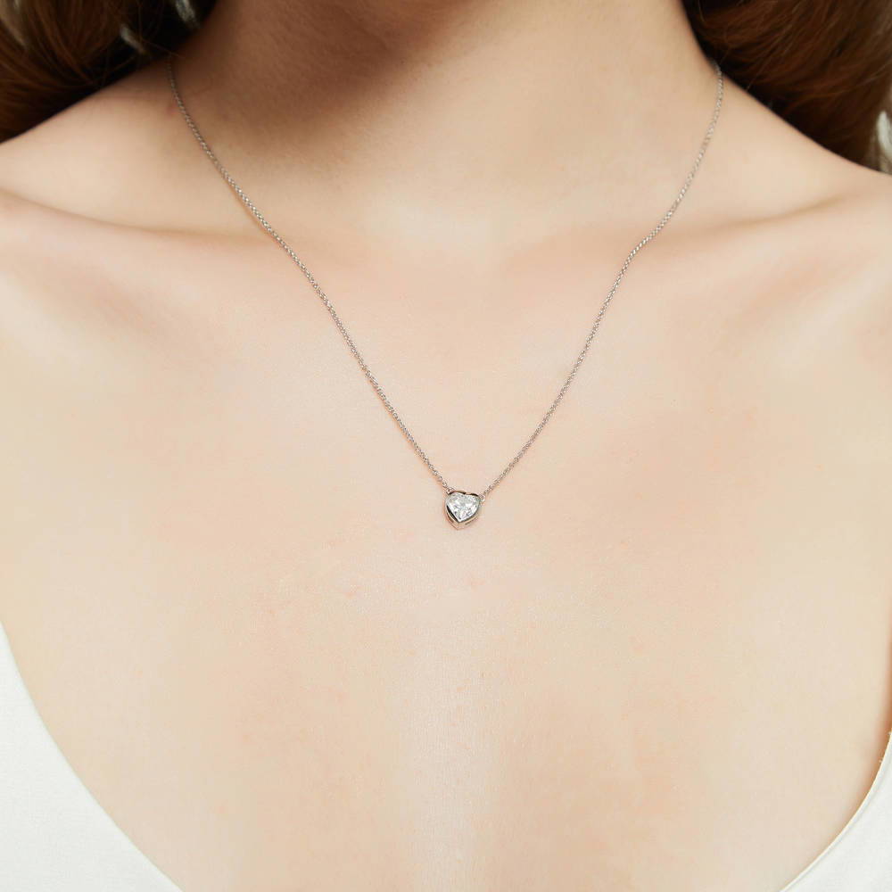Model wearing Solitaire Bezel Set Heart CZ Pendant Necklace in Sterling Silver 0.7ct, 2 of 6