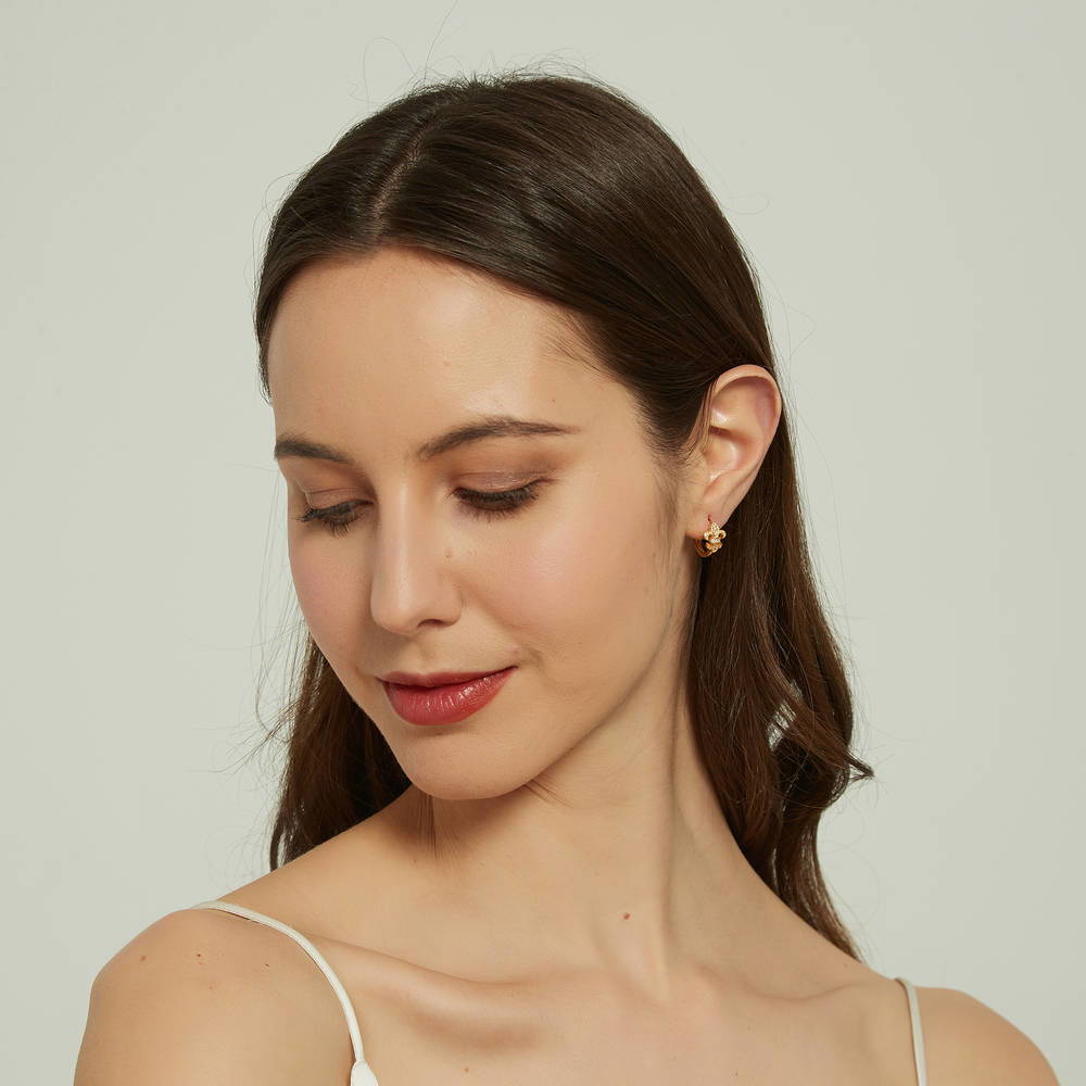 Model wearing Fleur De Lis CZ Small Huggie Earrings in Sterling Silver 0.5 inch