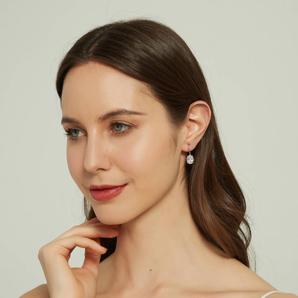 Model wearing Solitaire 5.6ct Oval CZ Leverback Dangle Earrings in Sterling Silver