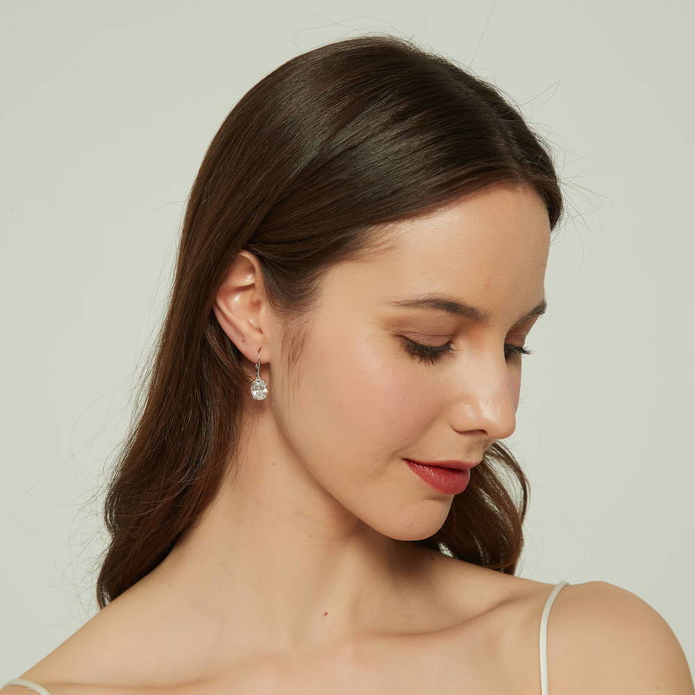 Model wearing Solitaire 5.6ct Oval CZ Leverback Dangle Earrings in Sterling Silver