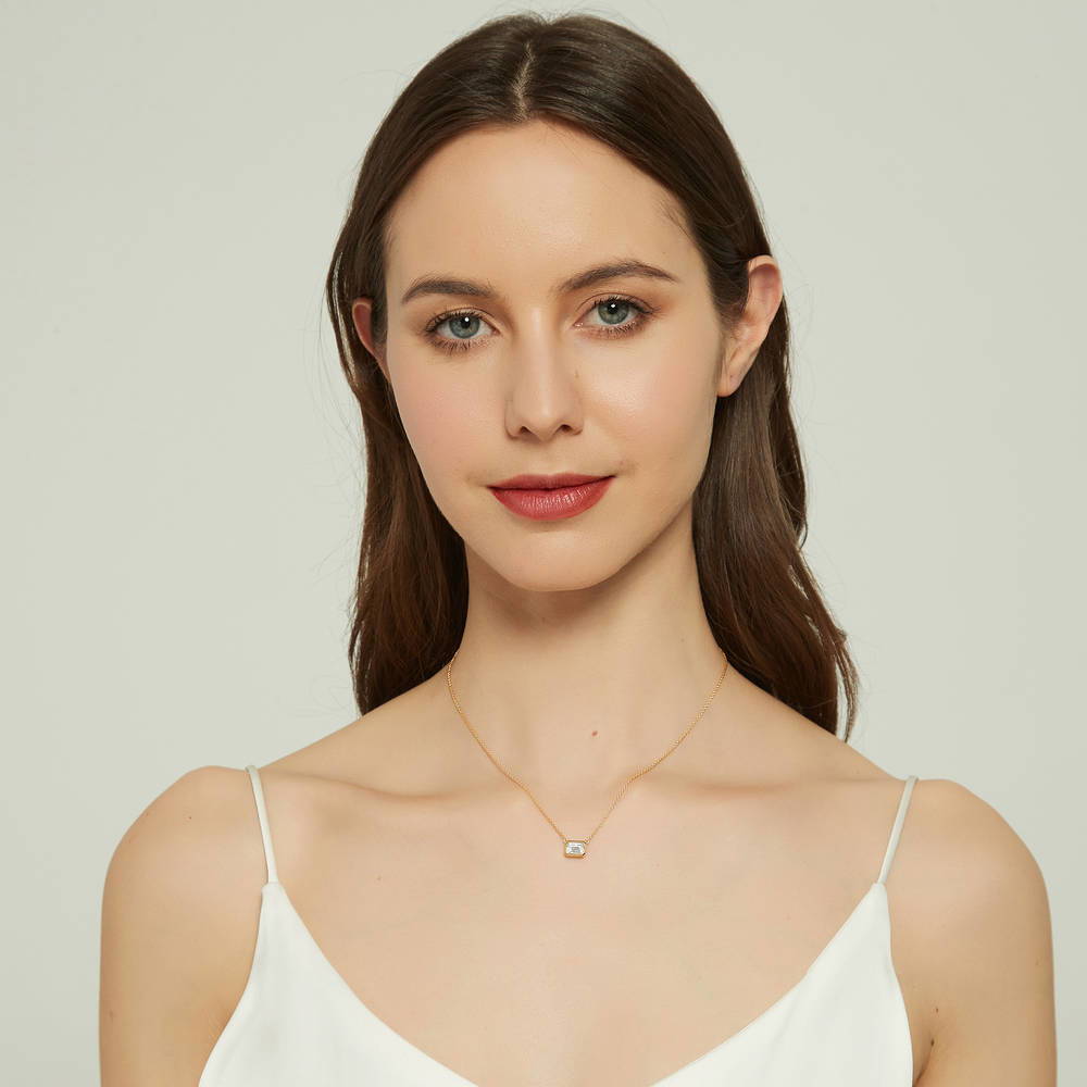 Model wearing Solitaire 1ct Bezel Set Emerald Cut CZ Necklace in Sterling Silver