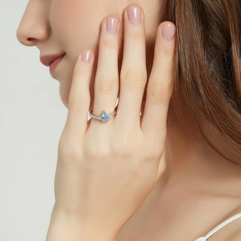 Model wearing 3-Stone Greyish Blue Pear CZ Ring in Sterling Silver