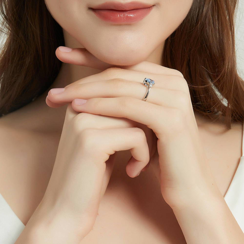 Model wearing 3-Stone Greyish Blue Pear CZ Ring in Sterling Silver