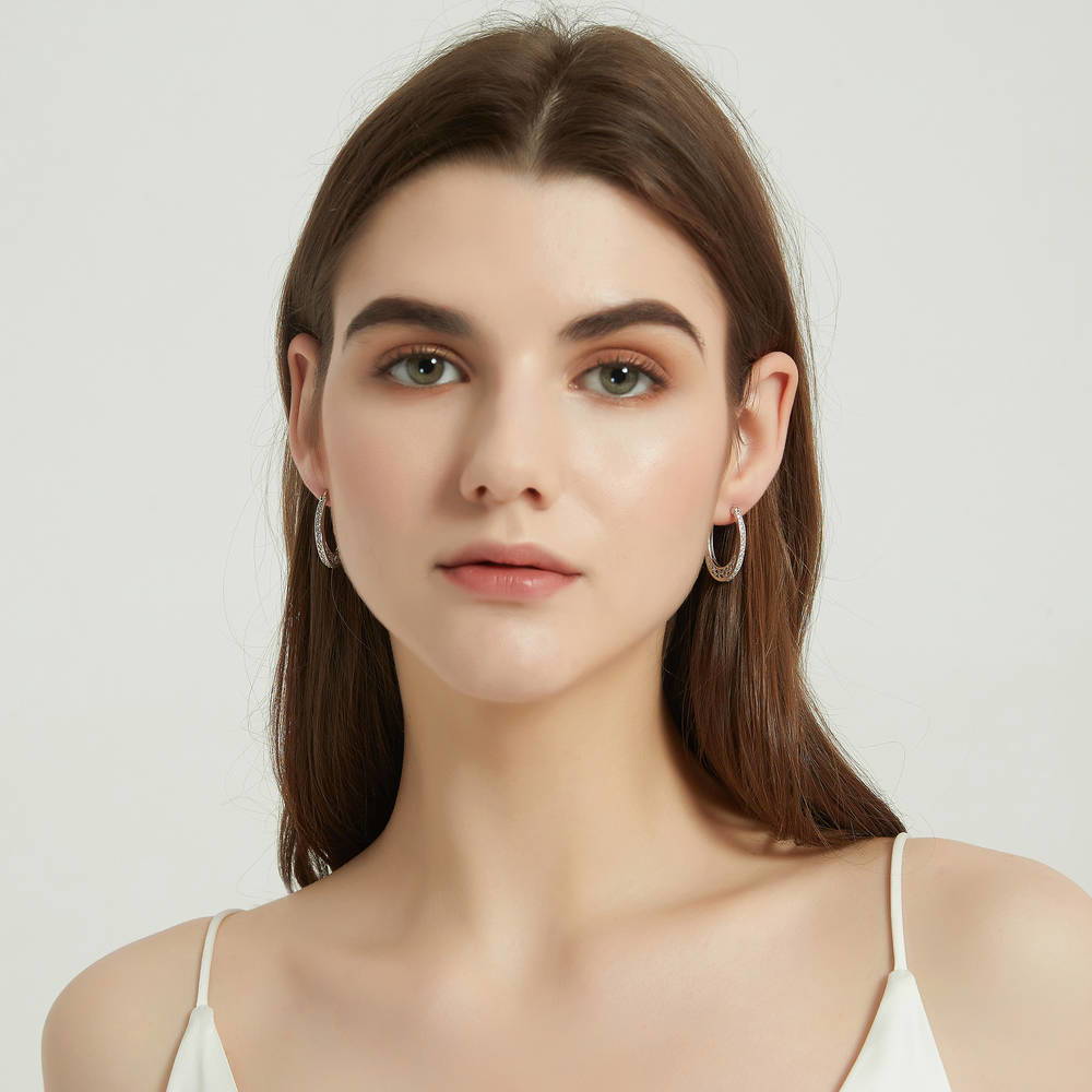 Model wearing Oval Bar CZ Medium Hoop Earrings in Sterling Silver 1 inch