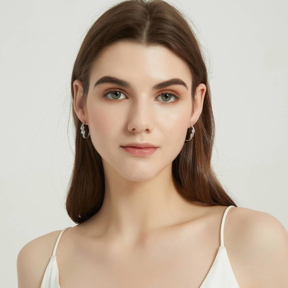 Model wearing Oval Bypass CZ Medium Hoop Earrings in Sterling Silver 0.96 inch