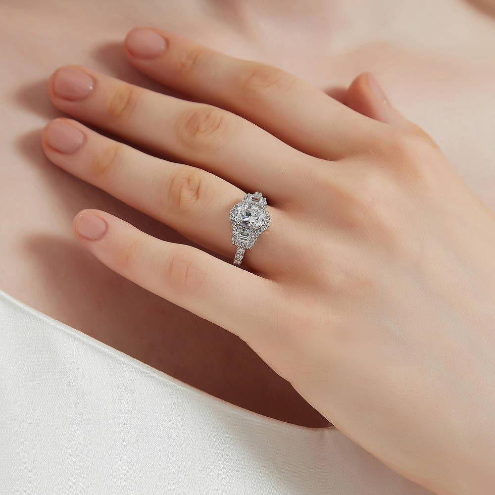 Model wearing 3-Stone Halo Oval CZ Ring in Sterling Silver