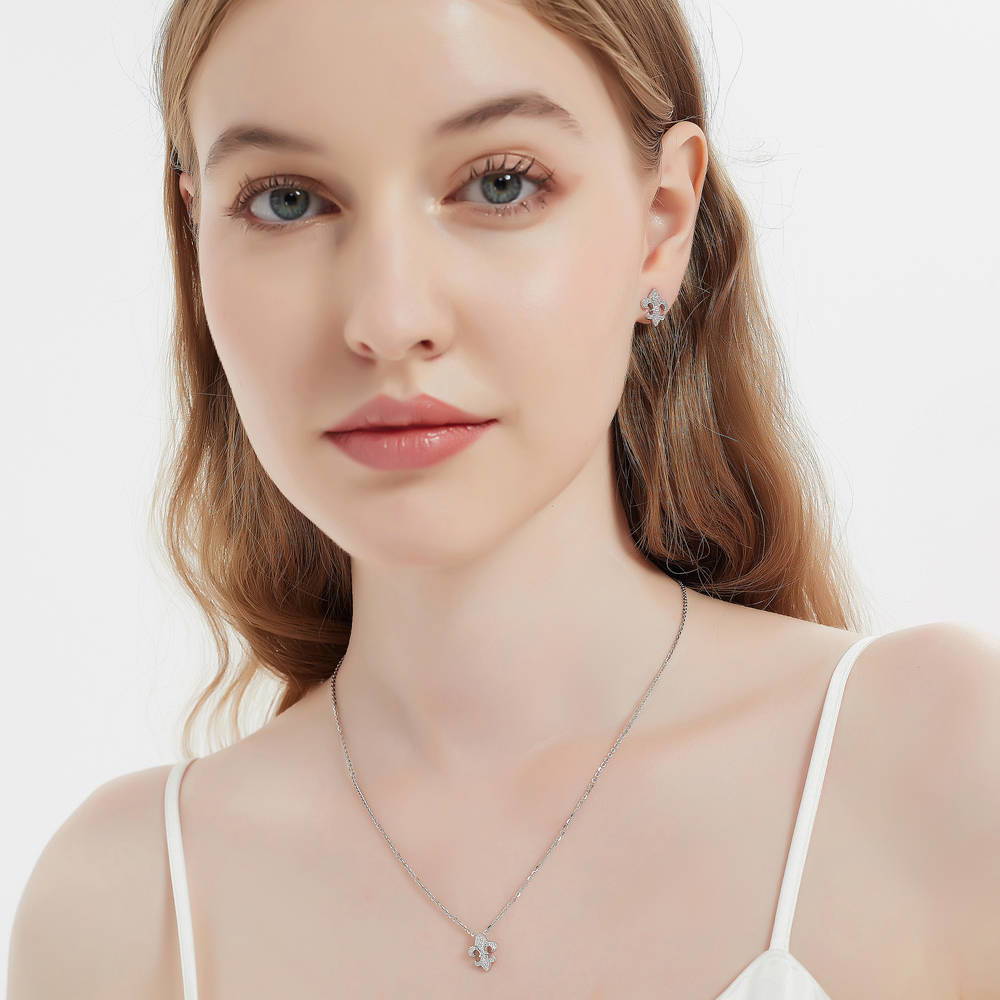 Model wearing Fleur De Lis CZ Necklace and Huggie Earrings Set in Sterling Silver