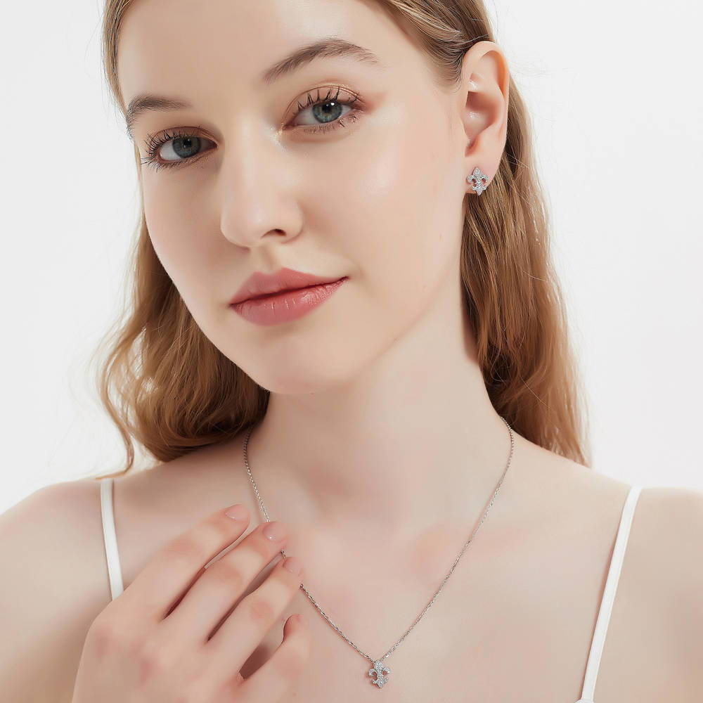 Model wearing Fleur De Lis CZ Necklace and Huggie Earrings Set in Sterling Silver