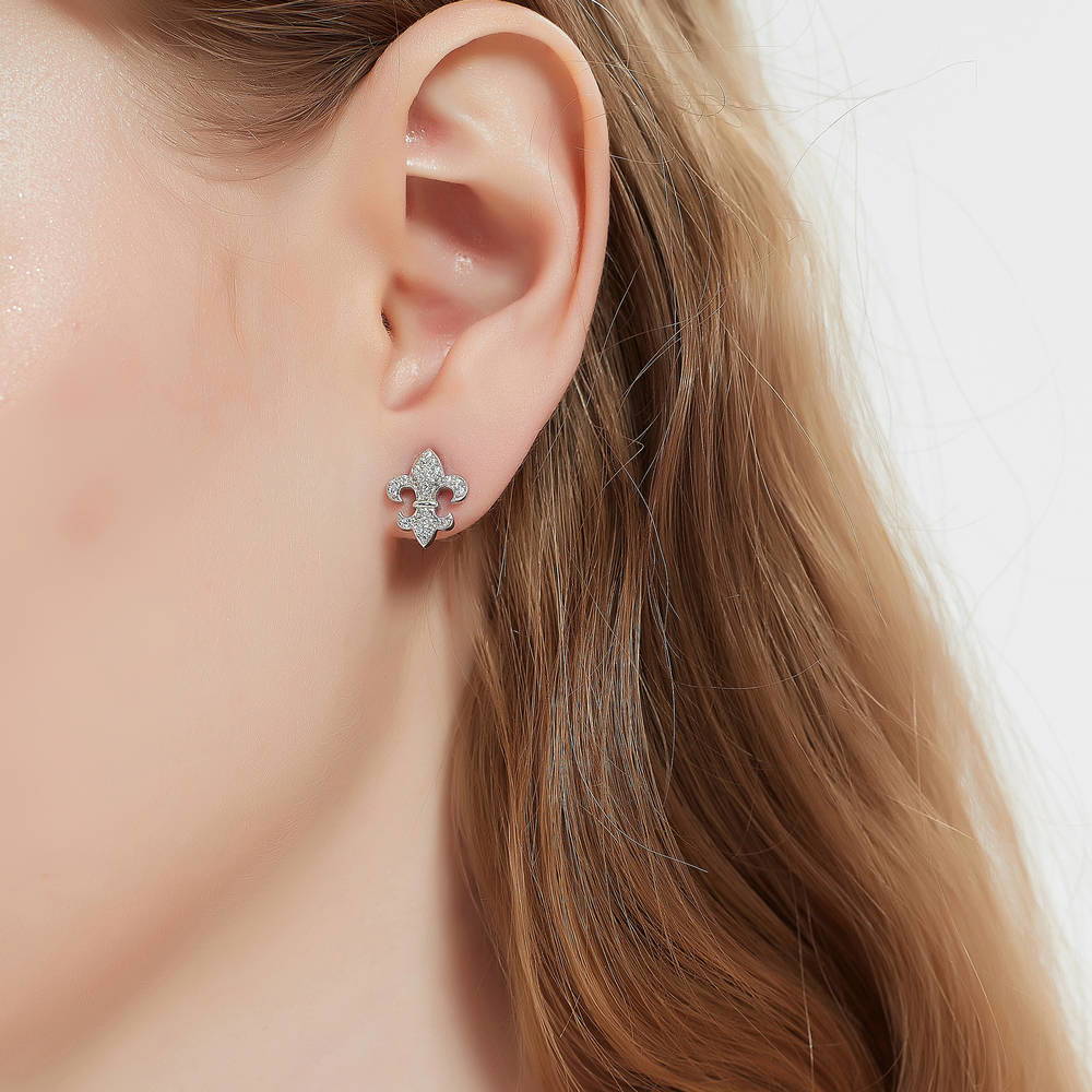 Model wearing Fleur De Lis CZ Stud Earrings in Sterling Silver